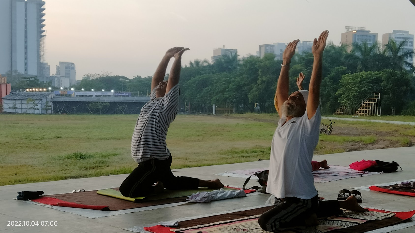 An elderly student stretching upward during yoga practice
